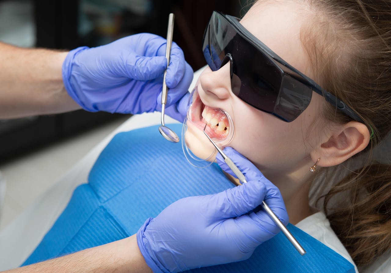 A child receiving dental care wearing protective goggles during treatment.